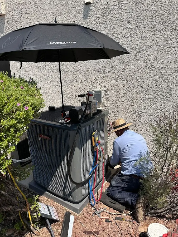 HVAC technician performing outdoor AC maintenance in Winfield