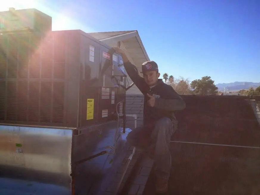 HVAC technician performing Air Duct Repair on a rooftop unit in Winfield